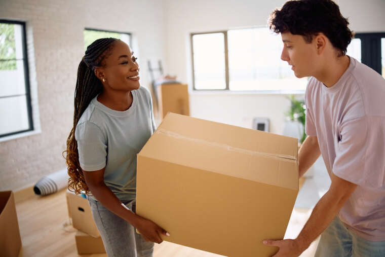 Residential Couple Carrying Cardboard Box